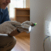 firefly gemini flash closeup of a home inspector using a flashlight near a wall outlet, natural indoor lig 845269